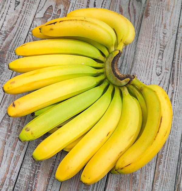 Fresh bananas on wooden table .